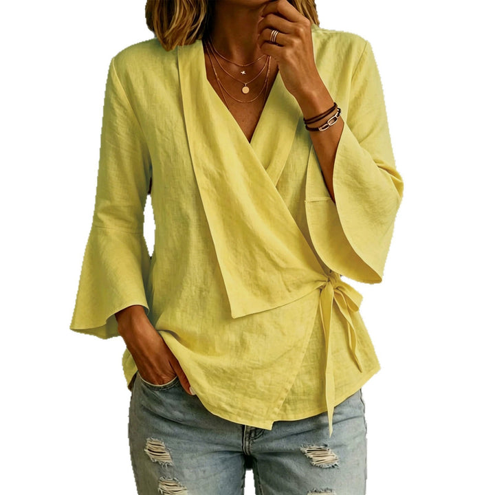 Moderna blusa donna asimmetrica con rever. Maniche svasate, versatile per outfit casual chic e ufficio.
