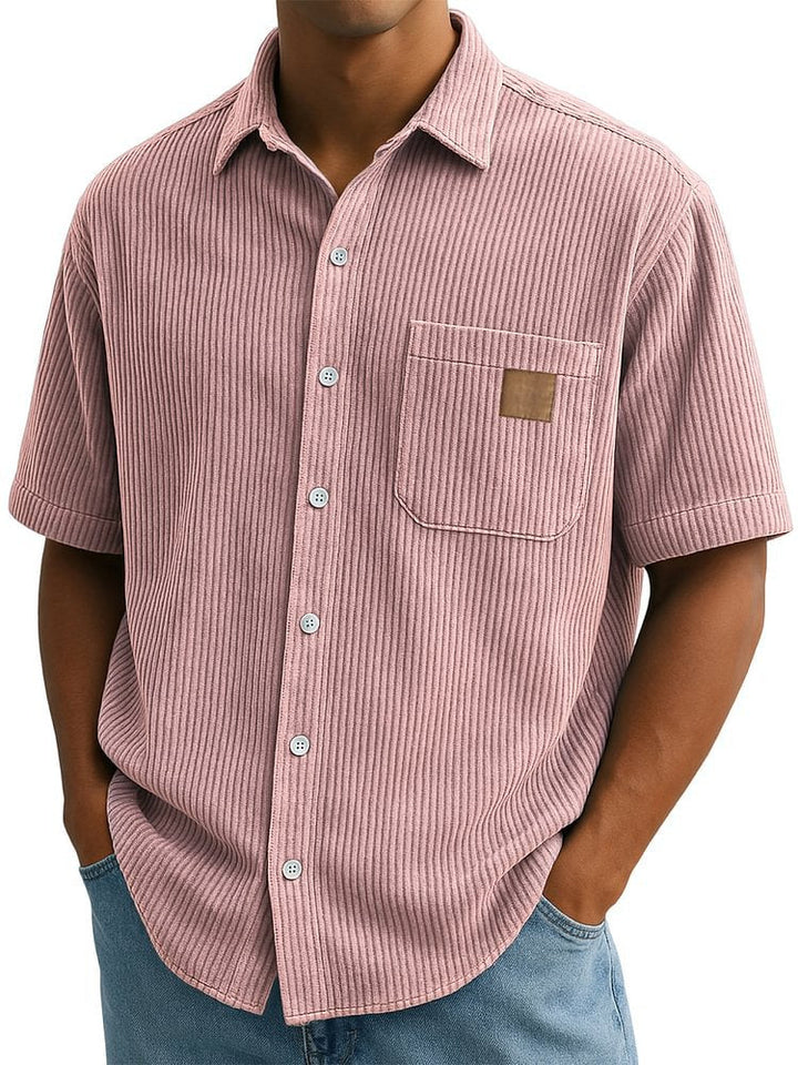 Primo piano: camicia uomo maniche corte, taschino effetto velluto. Dettaglio abbottonatura.