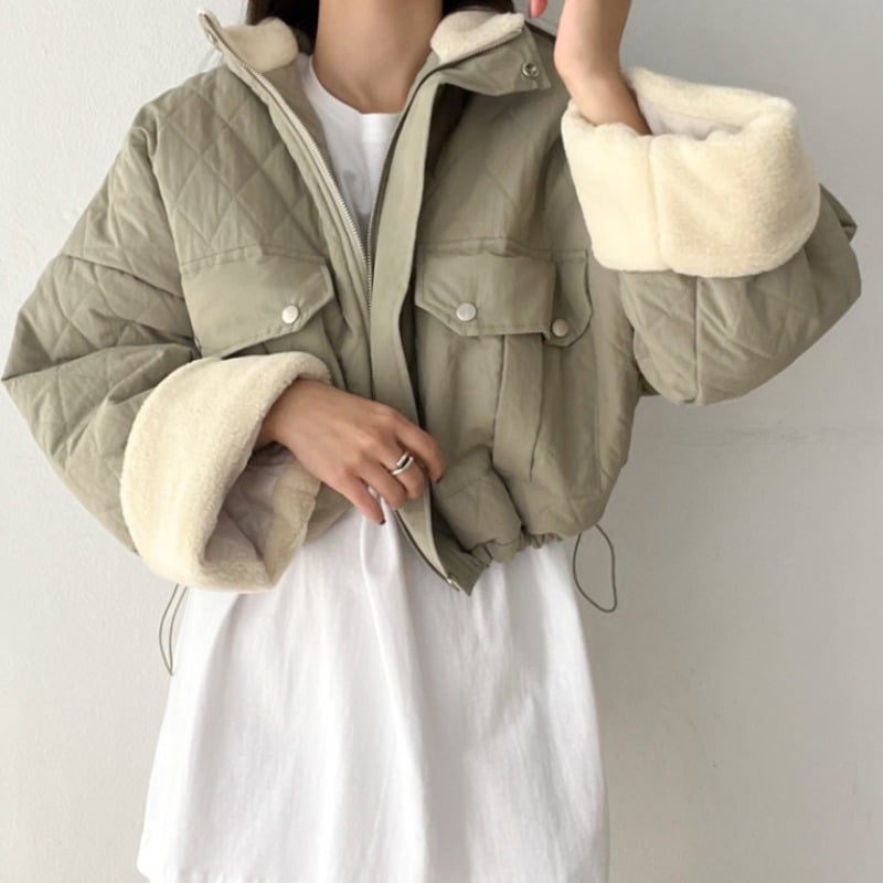 Calda giacca invernale donna con collo alto e vestibilità ampia. Abbigliamento freddo confortevole in grigio.