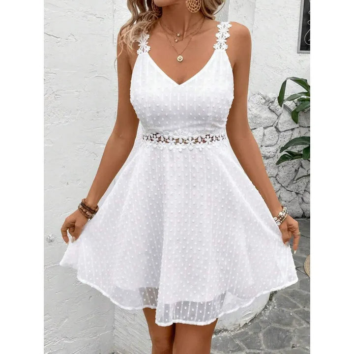 Vista posteriore abito mini donna plumetis con spalline in pizzo incrociate. Vestito estivo elegante.