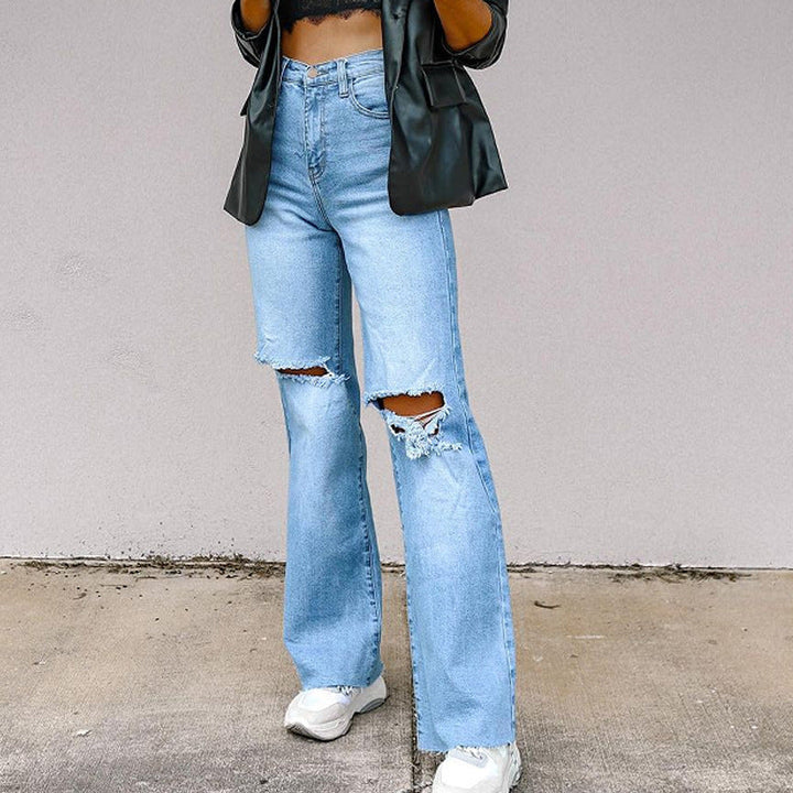 Dettaglio dei jeans donna a vita alta con effetto strappato, design gamba dritta per un outfit casual moderno.