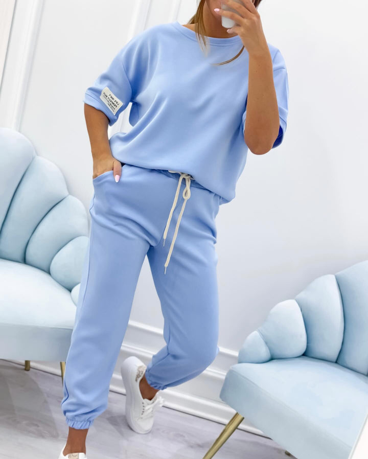 Donna che indossa un completo lounge comodo, set 2 pezzi con manica corta e pantaloni. Ideale per il tempo libero.