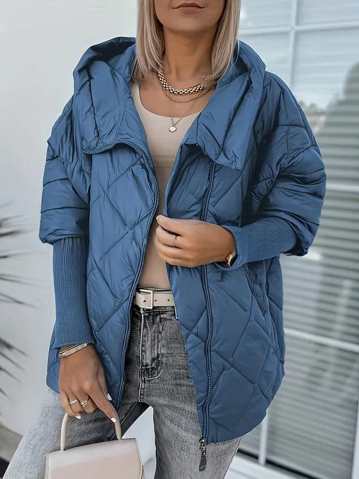 Piumino donna con cappuccio e zip. Giacca invernale calda, stile patchwork moderno ed elegante.