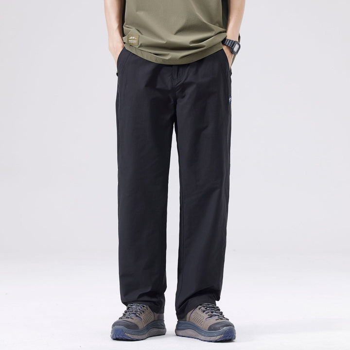 Pantaloni casual uomo con gamba dritta e vita media, in tinta unita nera, essenziali per la moda streetwear maschile.