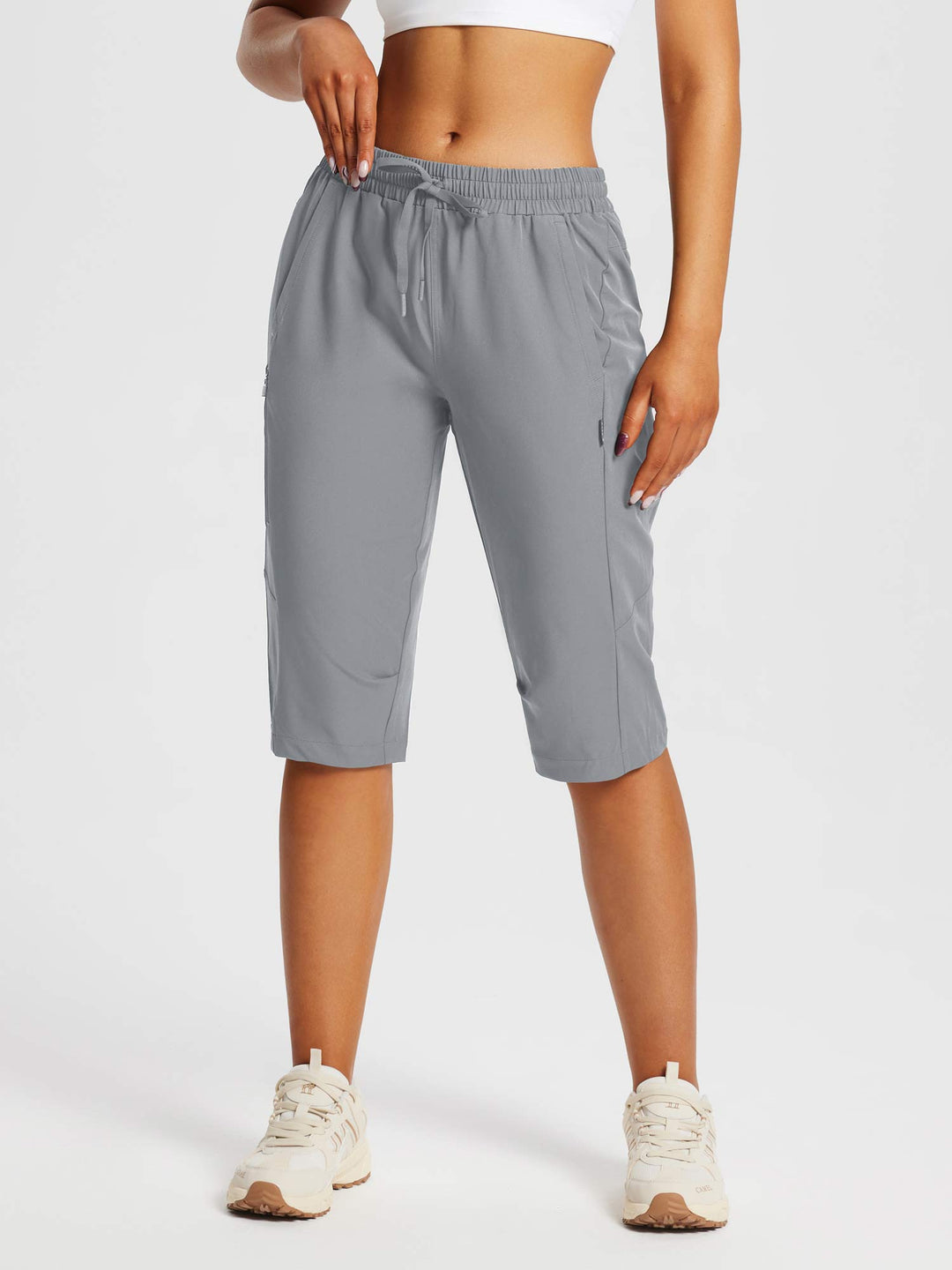 Pantaloncini capri sportivi da donna per l'estate, con protezione solare e tasche frontali.