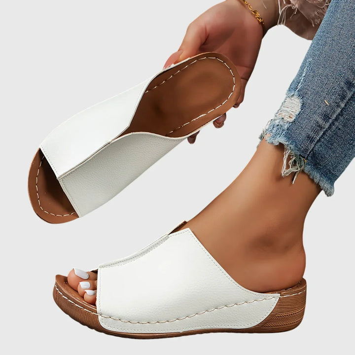 Ciabatte donna estive a zeppa bassa, aperte con fascia larga. Perfette per comfort piedi e look casual.