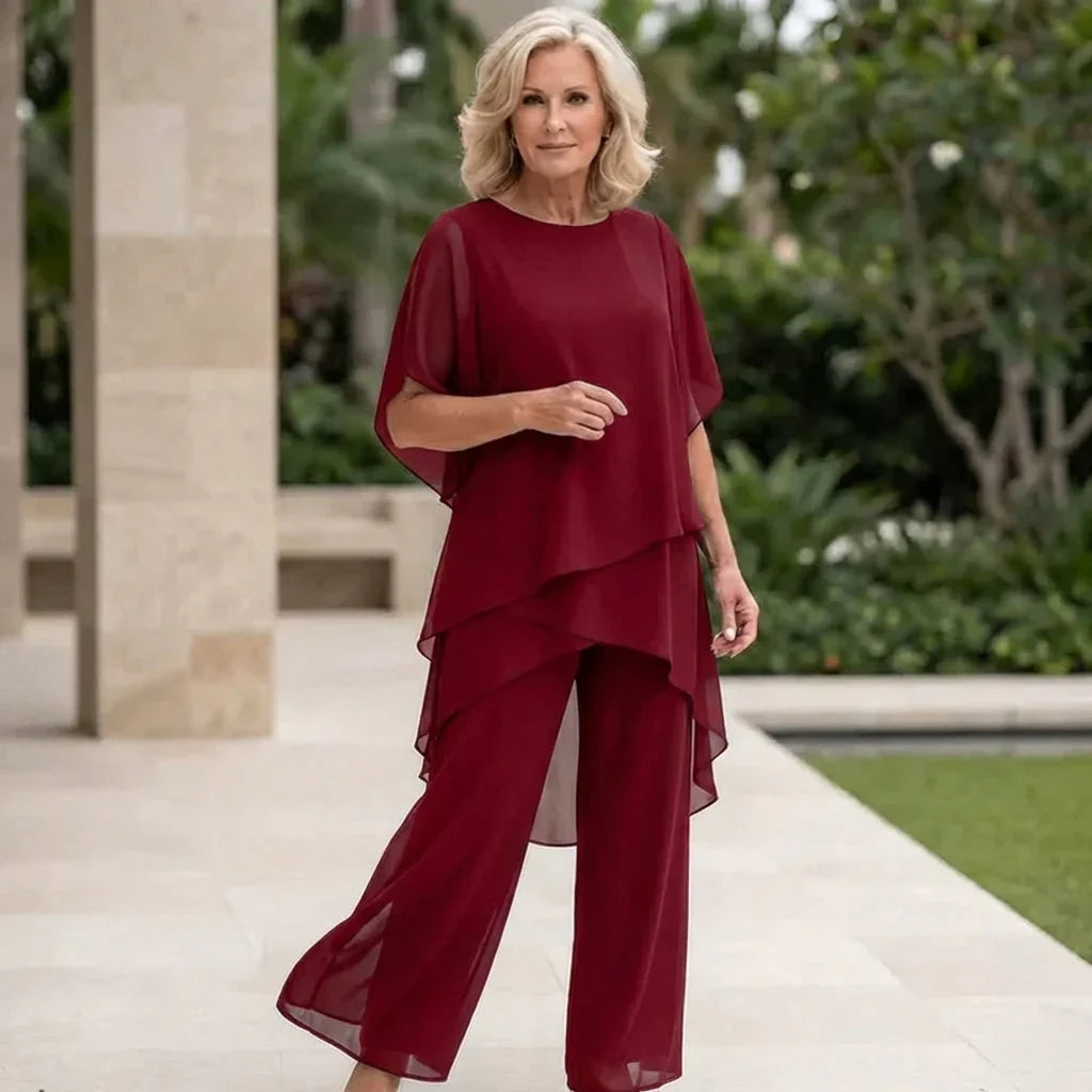 Moda donna: completo coordinato con top drappeggiato e pantaloni palazzo, un look serale contemporaneo e formale.
