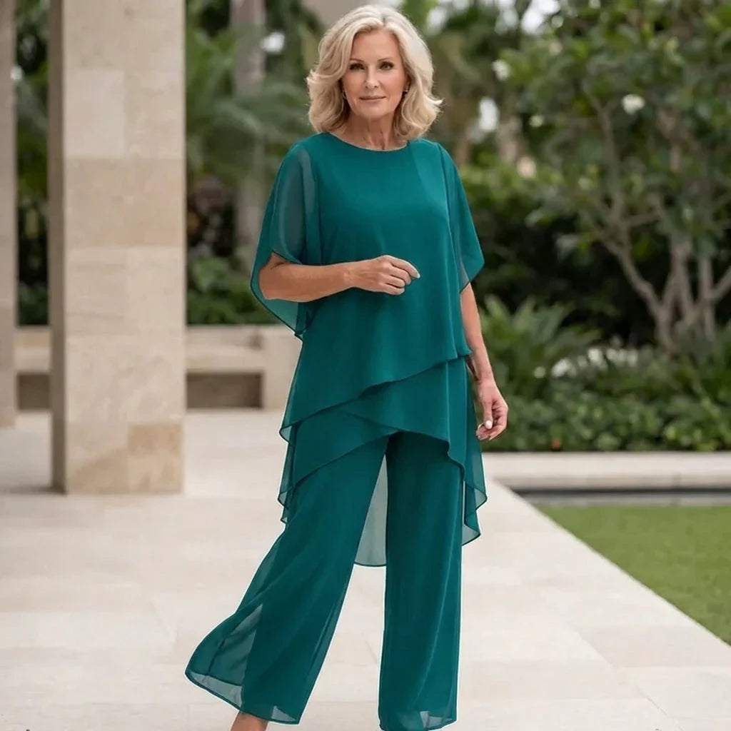 Completo donna elegante, top drappeggiato e pantaloni palazzo. Abbigliamento formale con vestibilità fluida e chic.