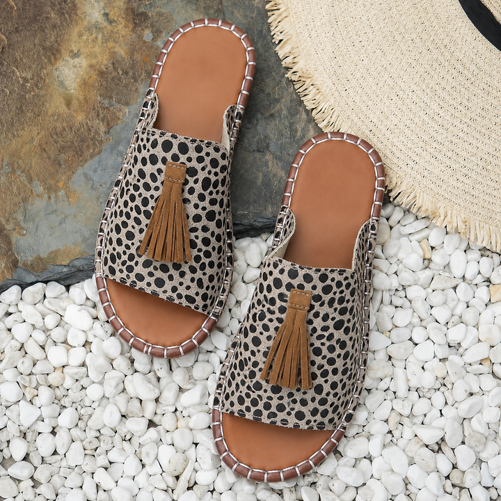 Sandali donna estivi slip-on con cinturino decorato e nappine, ideali per un outfit vacanziero.