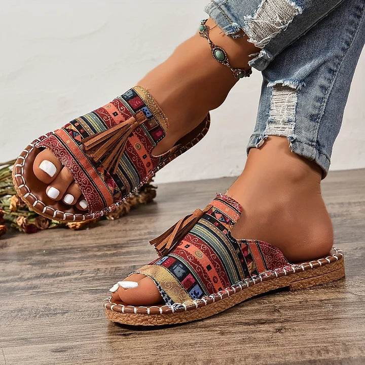 Sandali slip-on donna estivi con cinturino decorato e nappine, perfetti per un look boho-chic.