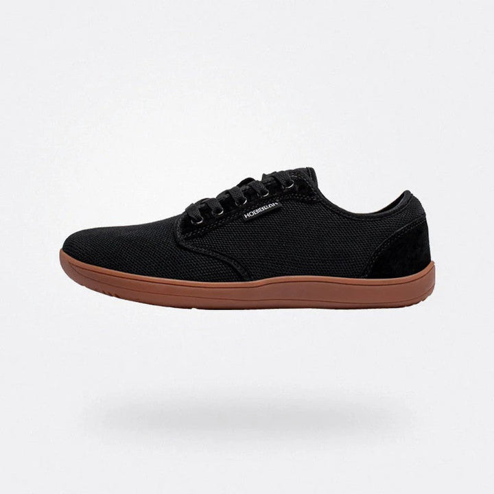 Scarpa barefoot unisex minimalista di profilo. Leggera e traspirante, offre comfort e flessibilità per camminata estiva.