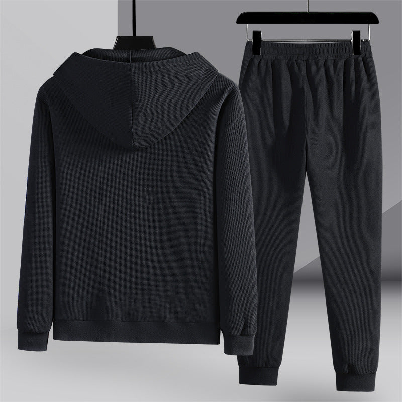 Elegante set sportivo uomo nero con felpa con cappuccio e pantaloni lunghi nido d'ape. Perfetto per il tempo libero.