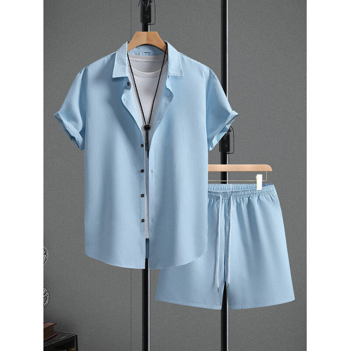 Moda uomo casual: set maglietta e pantaloncini neri con dinamico motivo a rombo, vista laterale.