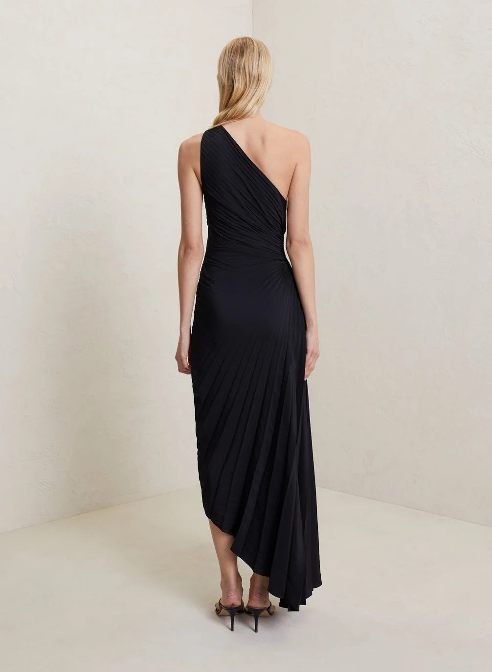 Abito lungo monospalla, plissettato, esprime eleganza e fluidità per un look da vera diva.