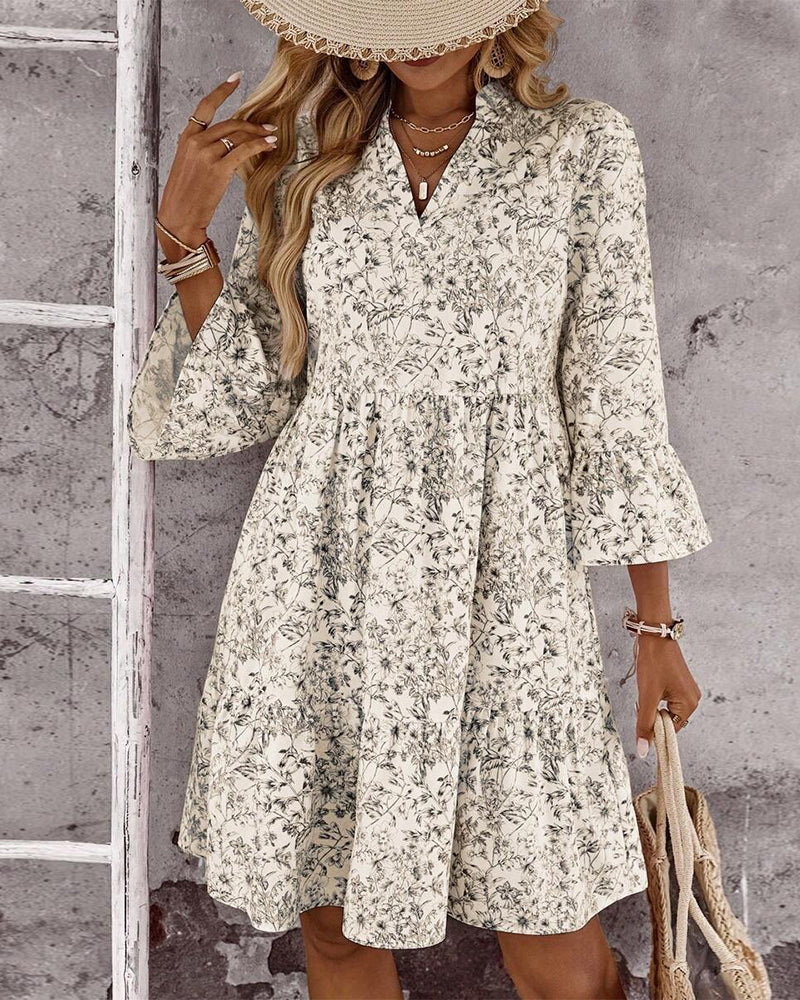 Dettaglio abito donna beige con raffinata stampa floreale, collo alto e maniche a volant. Vestito primaverile.