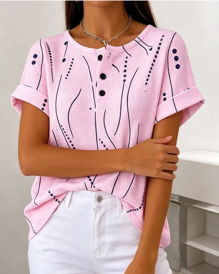 T-shirt donna versatile casual con stampa grafica e bottoni. Perfetta per look estivi e outfit di moda femminile.