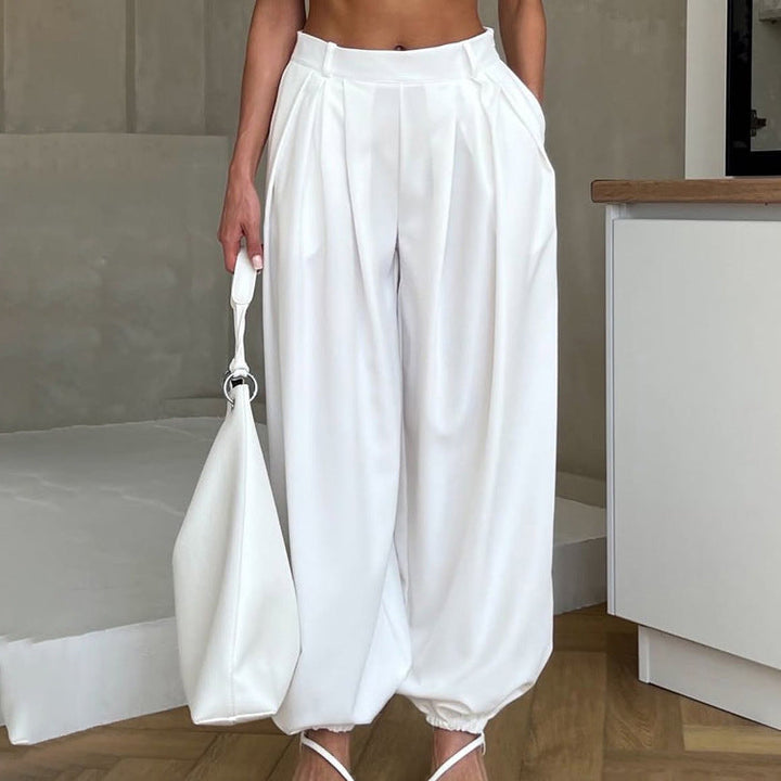 Eleganti pantaloni ampi da donna bianchi a vita alta, ideali per outfit estivi chic e alla moda.