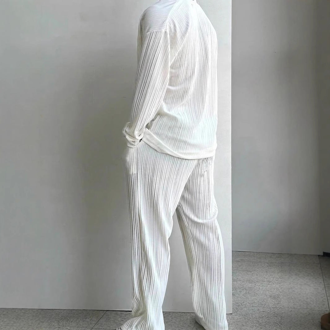Modello indossa completo uomo casual elegante bianco. Camicia e pantaloni tinta unita, per un look moderno e raffinato.