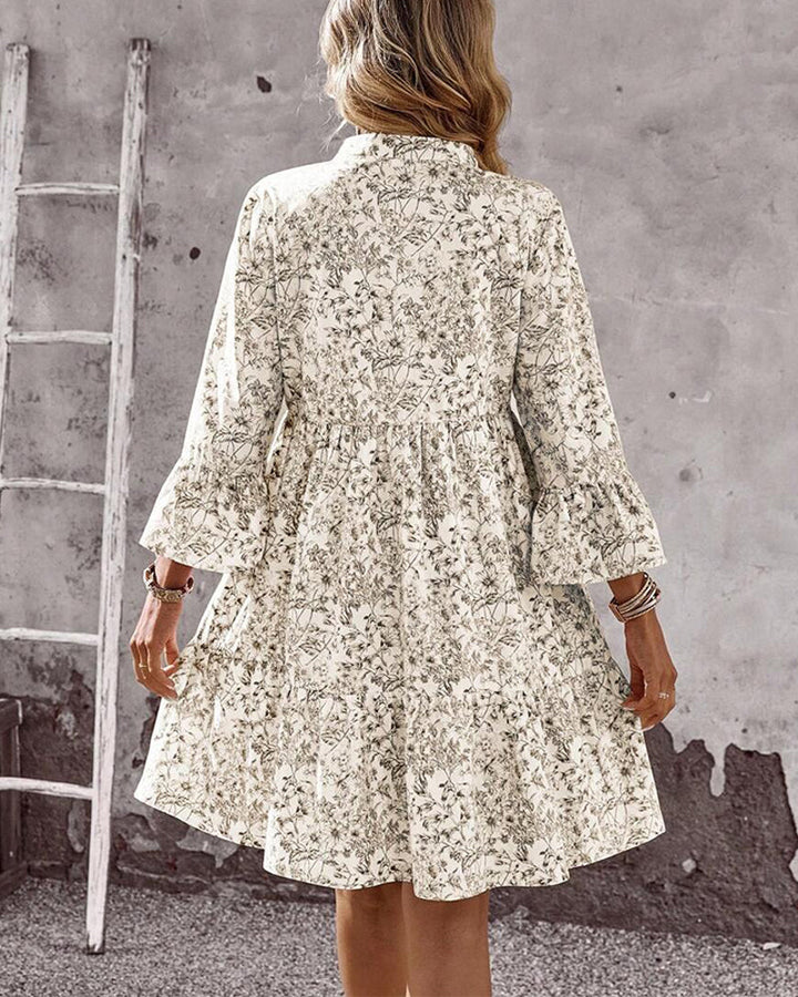 Abito donna a linea floreale beige, con maniche a volant vaporose e collo alto. Vestito midi primaverile moda.