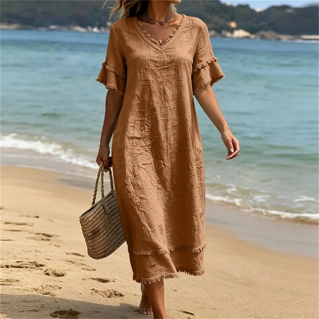 Abito elegante-casual bohémien con scollo a V e frange, ideale per le sere d'estate.