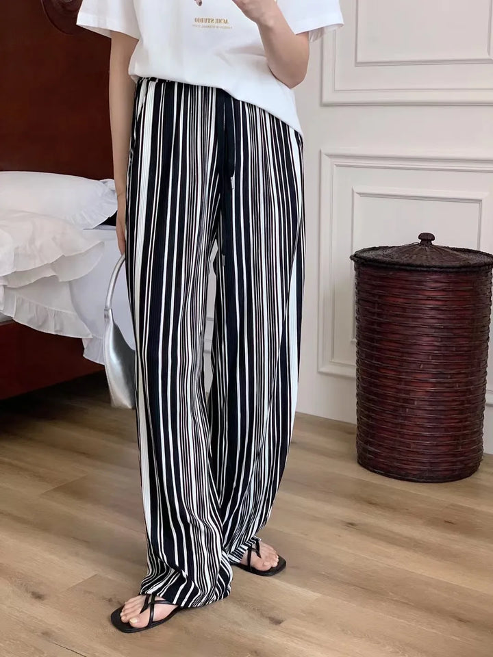 Pantaloni donna a gamba larga con tasche, a righe verticali. Ideali per outfit eleganti e alla moda.