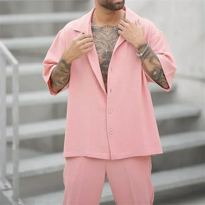 Completo uomo due pezzi oversize grigio, camicia a maniche lunghe e pantaloni ampi, stile moderno.