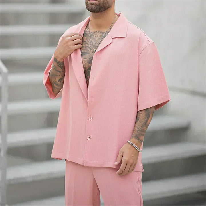 Completo moda uomo oversize rosa, camicia e pantaloni eleganti, per un look contemporaneo e di tendenza.