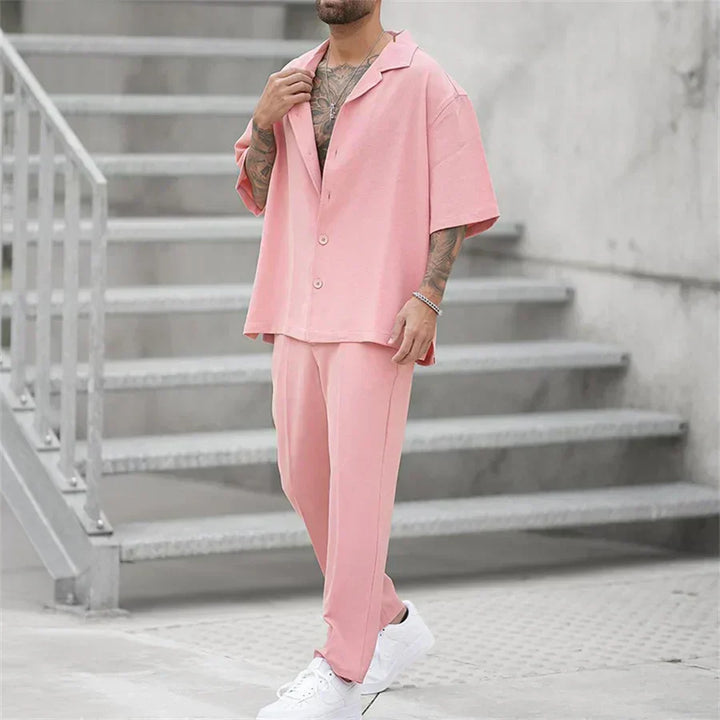 Completo uomo moderno oversize, camicia e pantaloni neri, essenziale e versatile per look eleganti o casual.