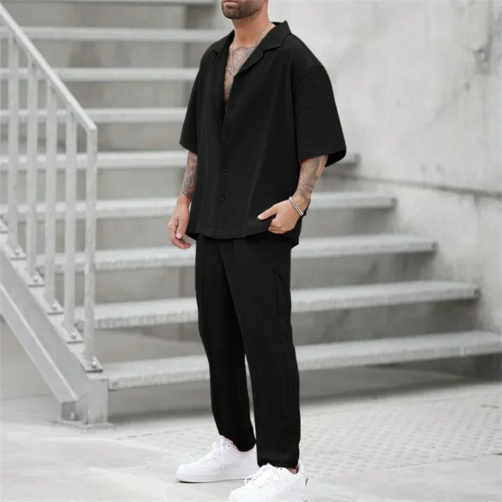 Completo oversize uomo camicia e pantaloni, disponibile in nero, grigio e rosa, ideale per outfit vari.