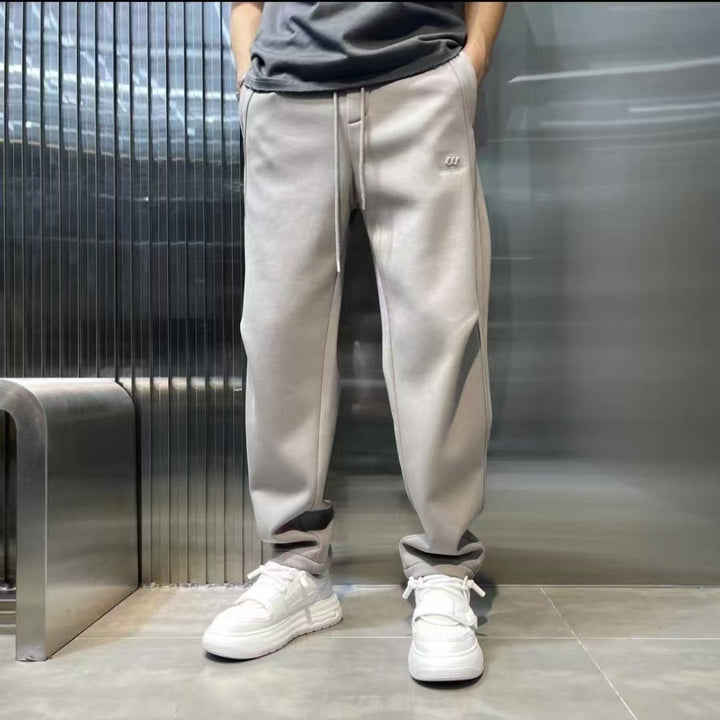 Pantaloni jogging uomo a vita alta, vestibilità comoda e gamba affusolata, stile streetwear.