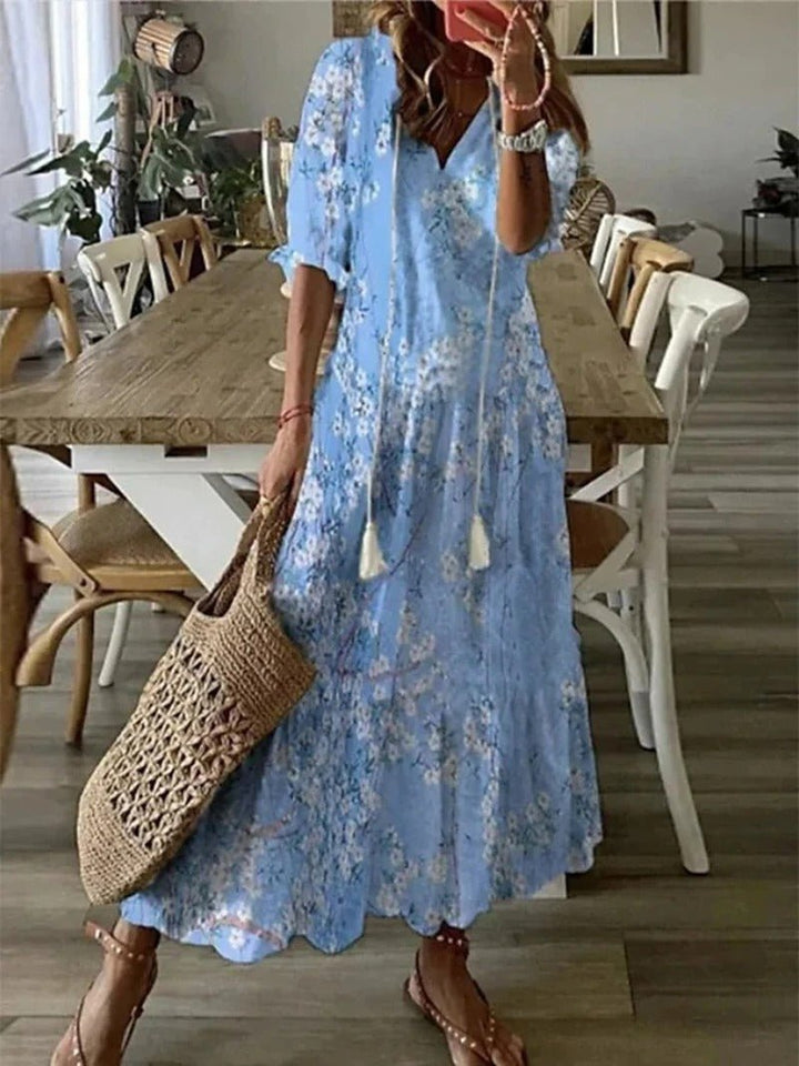 Donna in abito maxi bohémien fluido, ideale per vacanze estive, spiaggia e look casual-elegante.