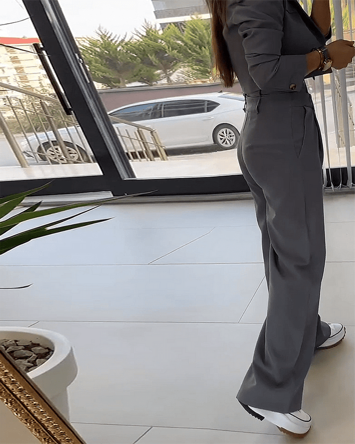 Modello di tailleur donna grigio moda, con blazer strutturato e pantaloni slim fit, per un outfit professionale.