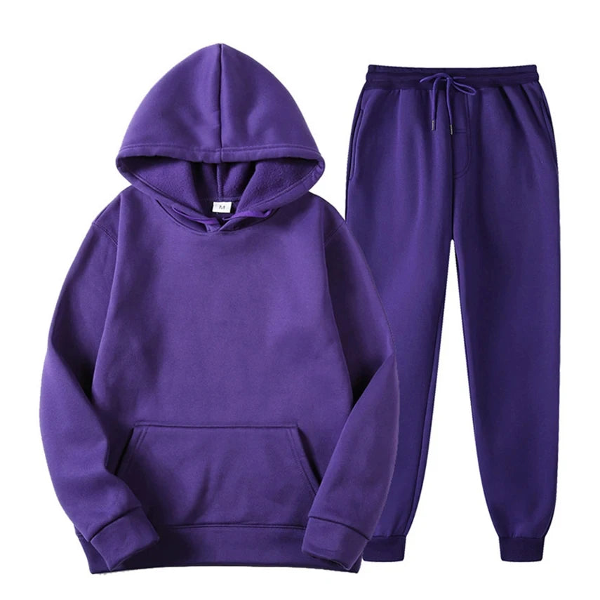 Tuta uomo casual chic: felpa con cappuccio e pantaloni neri, un must-have per comfort e stile urbano.