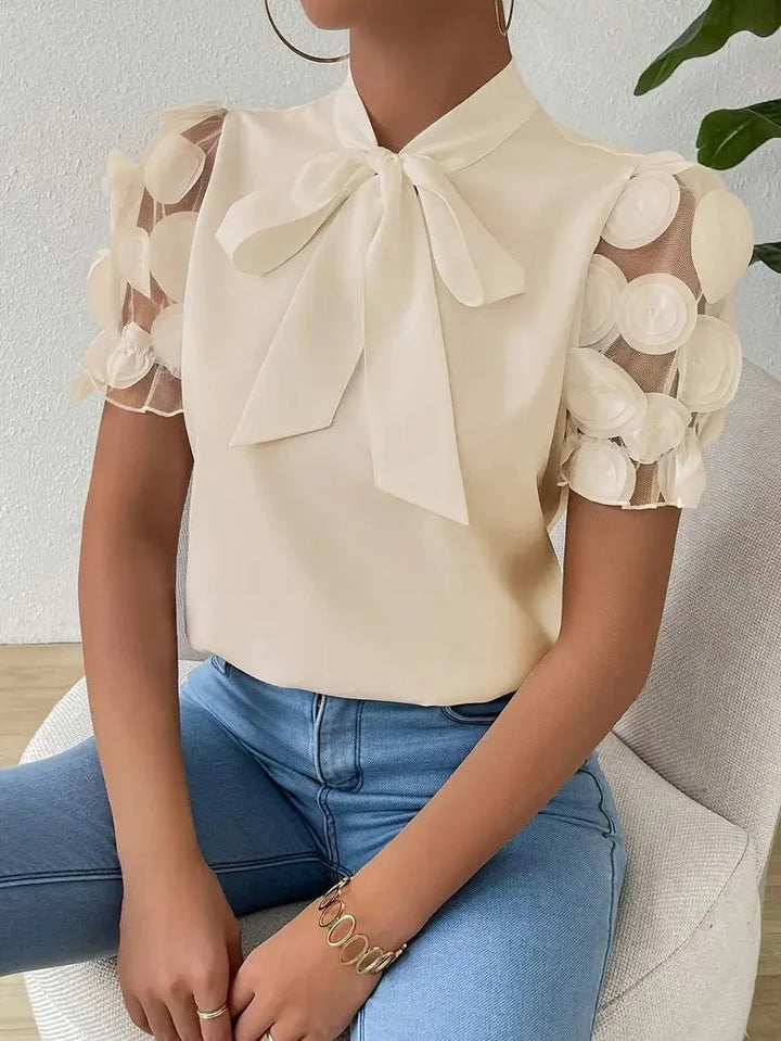 Camicetta donna elegante con fiocco, maniche in tulle e delicate rose 3D. Perfetta per occasioni speciali.
