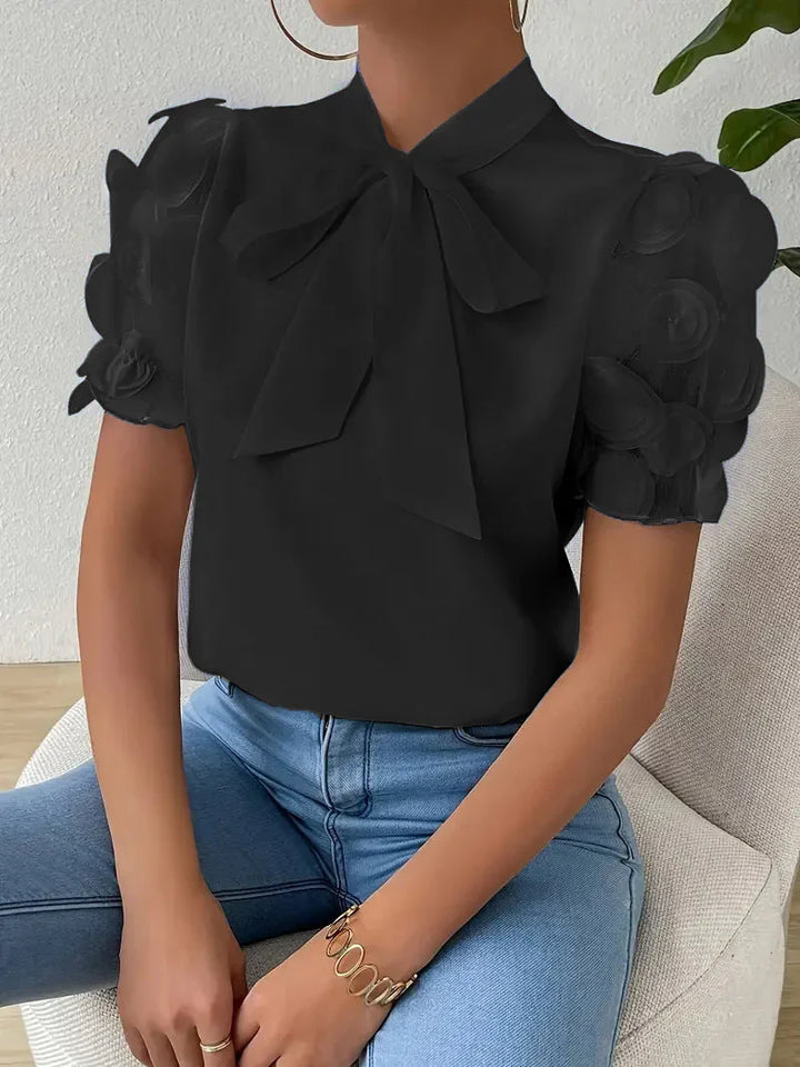 Elegante camicetta donna con fiocco, maniche a sbuffo in tulle e rose 3D. Perfetta per un look romantico.