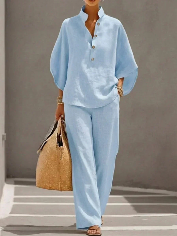 Camicia elegante donna con maniche a pipistrello abbinata a pantaloni larghi. Completo due pezzi per un look sofisticato.