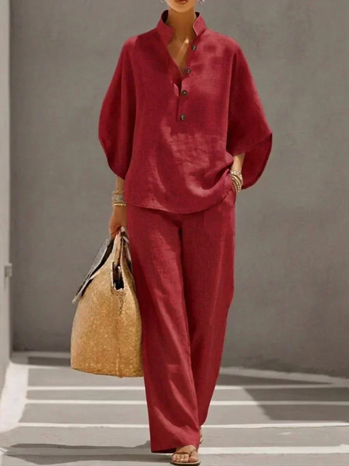 Outfit donna elegante con camicia dalle maniche ampie a pipistrello e pantaloni palazzo. Set due pezzi primavera.
