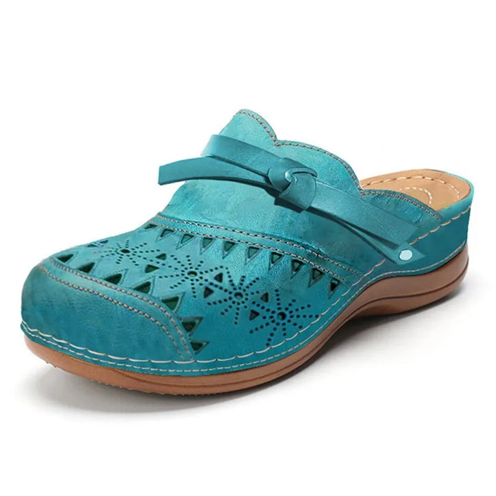 Zoccoli donna con fiocco e cinturino regolabile, mules traforate ammortizzate per comfort quotidiano.