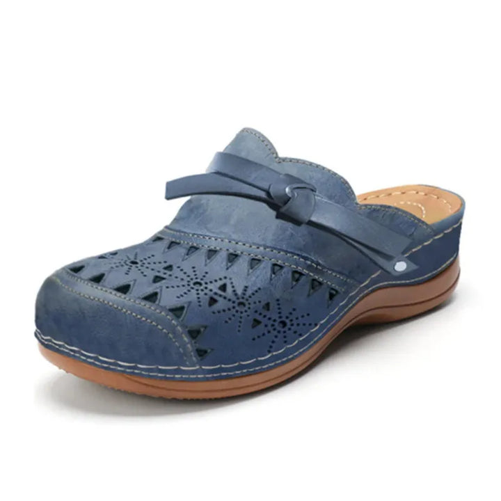 Dettaglio fiocco e traforature su zoccoli donna, mules ammortizzate per un comfort femminile e alla moda.