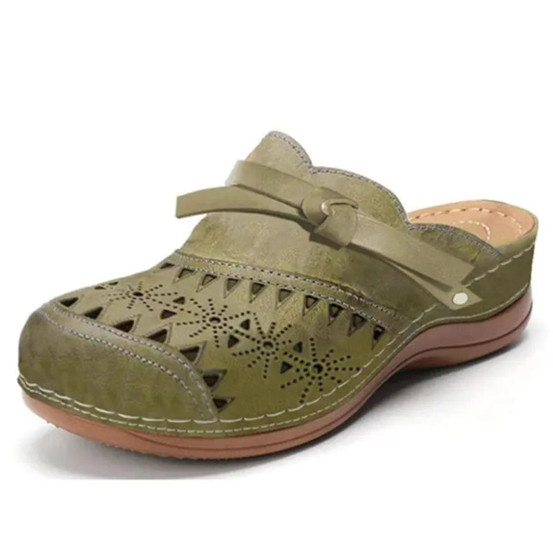 Calzature estive donna: zoccoli mules traforati con fiocco, ideali per comfort casual e stile femminile.