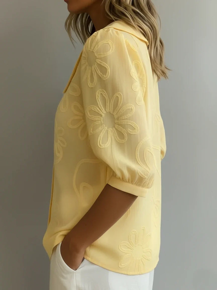 Dettaglio del ricco ricamo floreale su blusa da donna. Perfetta per un tocco elegante e primaverile.