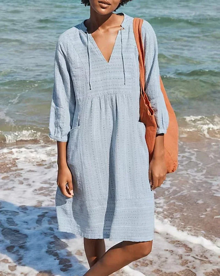 Vestito tunica da donna con cappuccio, scollo a V e maniche arrotolabili. Stile casual e confortevole.