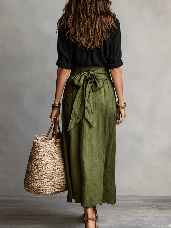 Elegante gonna nera a vita alta da donna, con cintura e pratica zip laterale. Stile fluido e moderno.