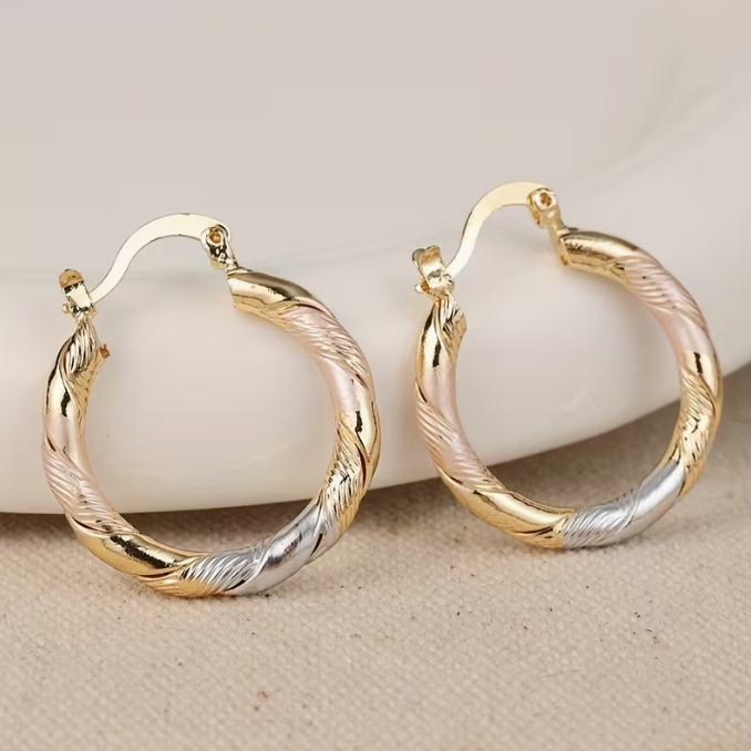 Eleganti orecchini a cerchio intrecciati tricolore oro, argento e rosa per donna. Accessori moda placcati.