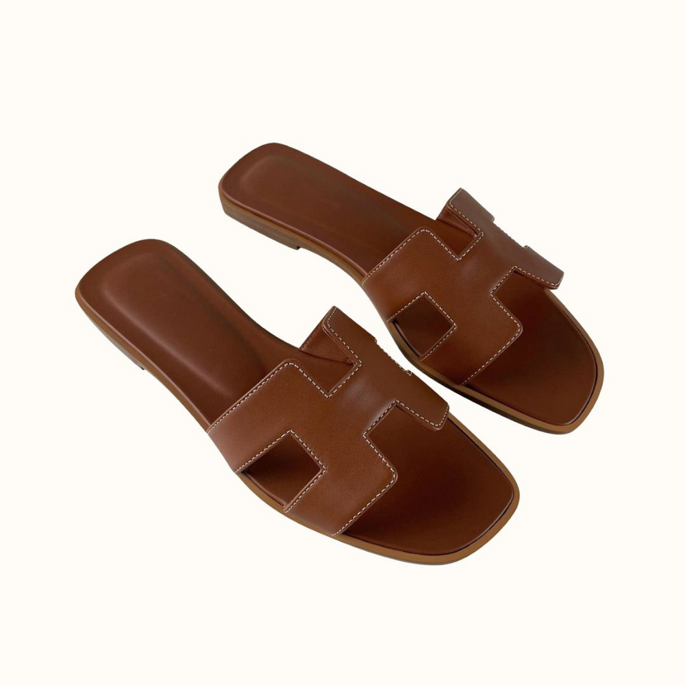 Eleganti sandali da donna bianchi con fasce ad H e tacco basso. Versatili per ogni occasione estiva.