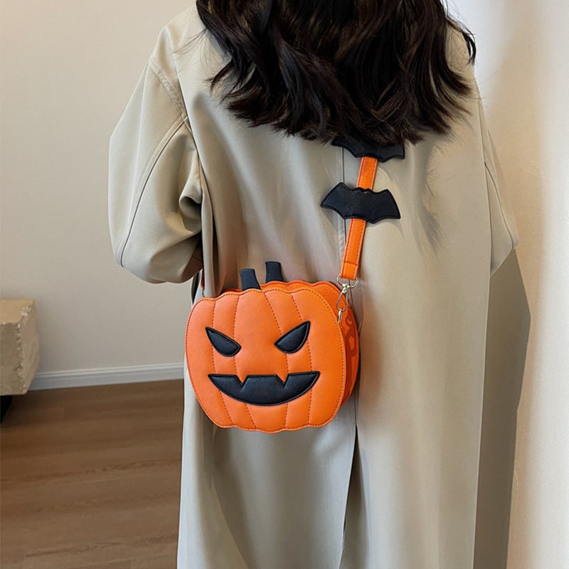 Elegante borsa a tracolla da donna con design Halloween, zucca arancione e pipistrelli decorativi.