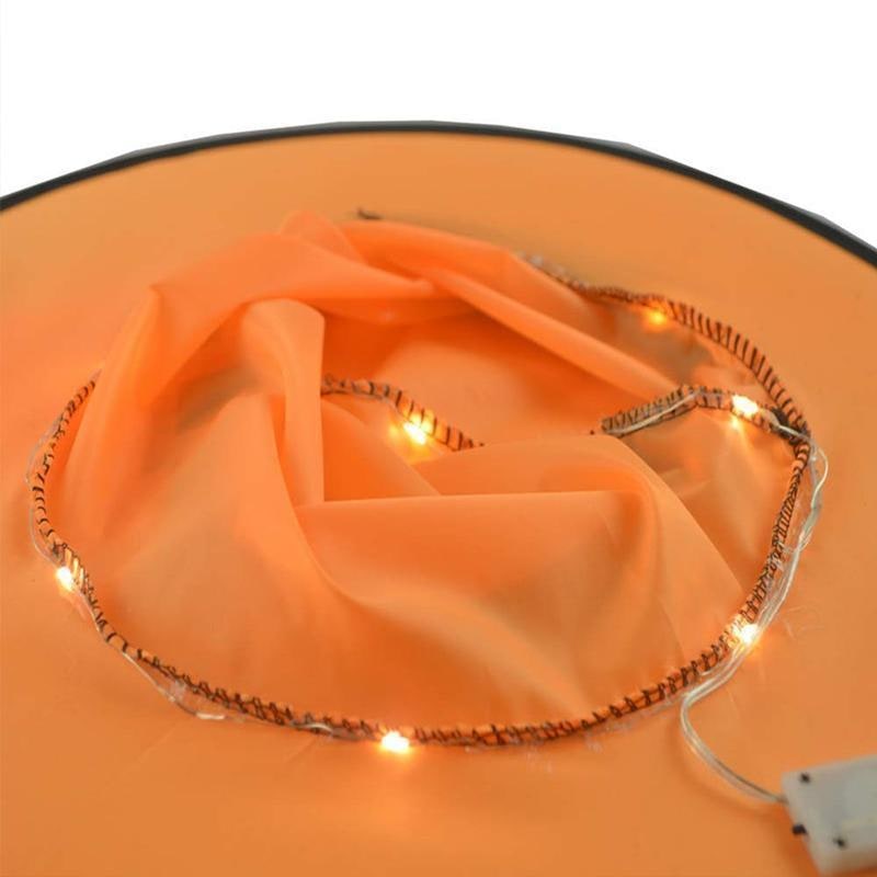 Dettaglio ravvicinato di un cappello da strega nero con luci LED viola/arancio accese, atmosfera Halloween.