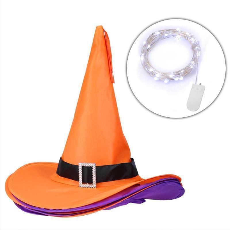 Cappello da strega Halloween nero appeso, illuminato da luci LED per decorazione festa o esterno notturno.