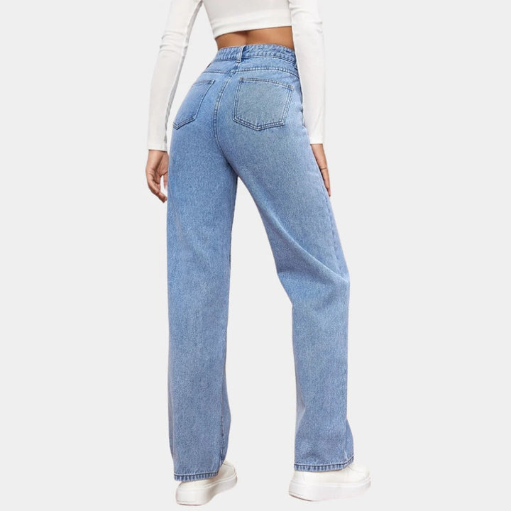 Donna con jeans larghi a vita alta, gamba dritta, in denim, stile casual ed elegante.