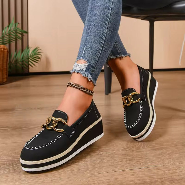 Scarpe slip-on donna con plateau per maggiore altezza e catena dorata, comode e adatte all'ufficio.